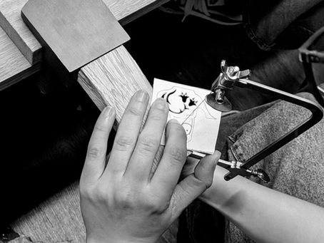 Saw piercing an intricate pendant design.