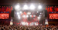 Dynamic concert scene at Budapest Park with a live band performing under bright stage lights and a cheering crowd, captured for an event videography production