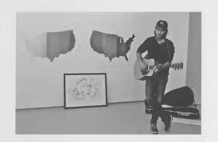 man performing on guitar in front painting on plastic pollution in and the 5 gyres by artist Barbara Benish