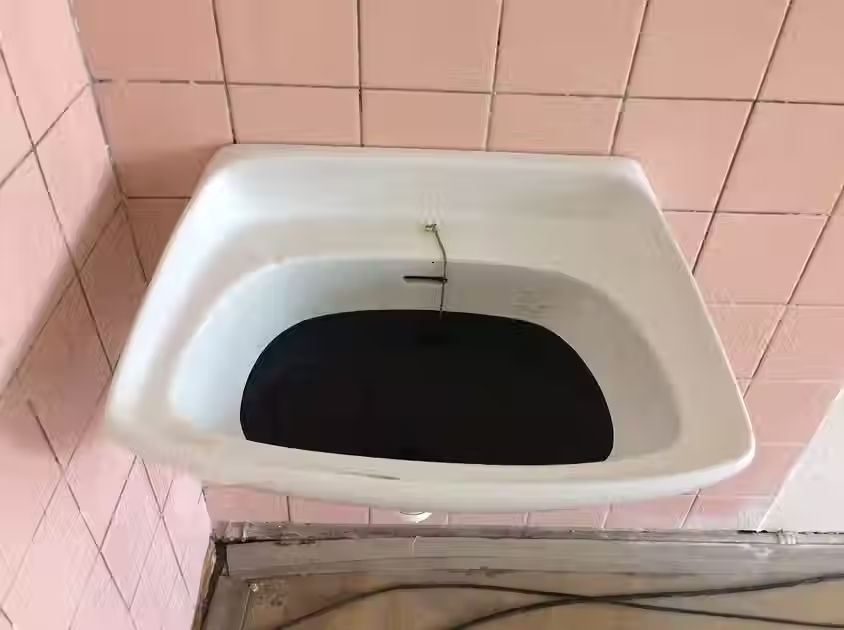 installation by Barbara Benish for '4+4 Dny v Pohybu' in Prague of black oil in sink