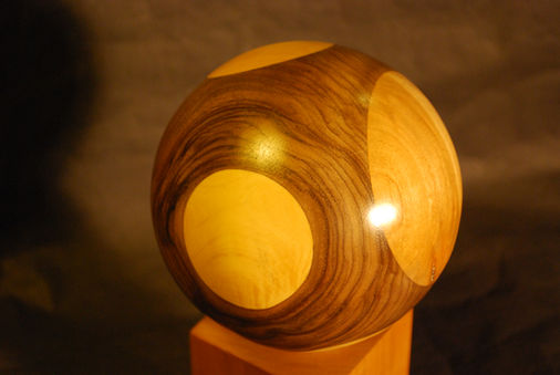 Une sphère tournée en noyer, buis et merisier.