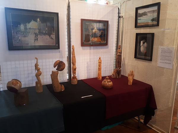 Exposition de sculptures et de pastels. On voit sur une table 8 sculptures et 4 pastels de l'artiste Jacques ARNAUD
