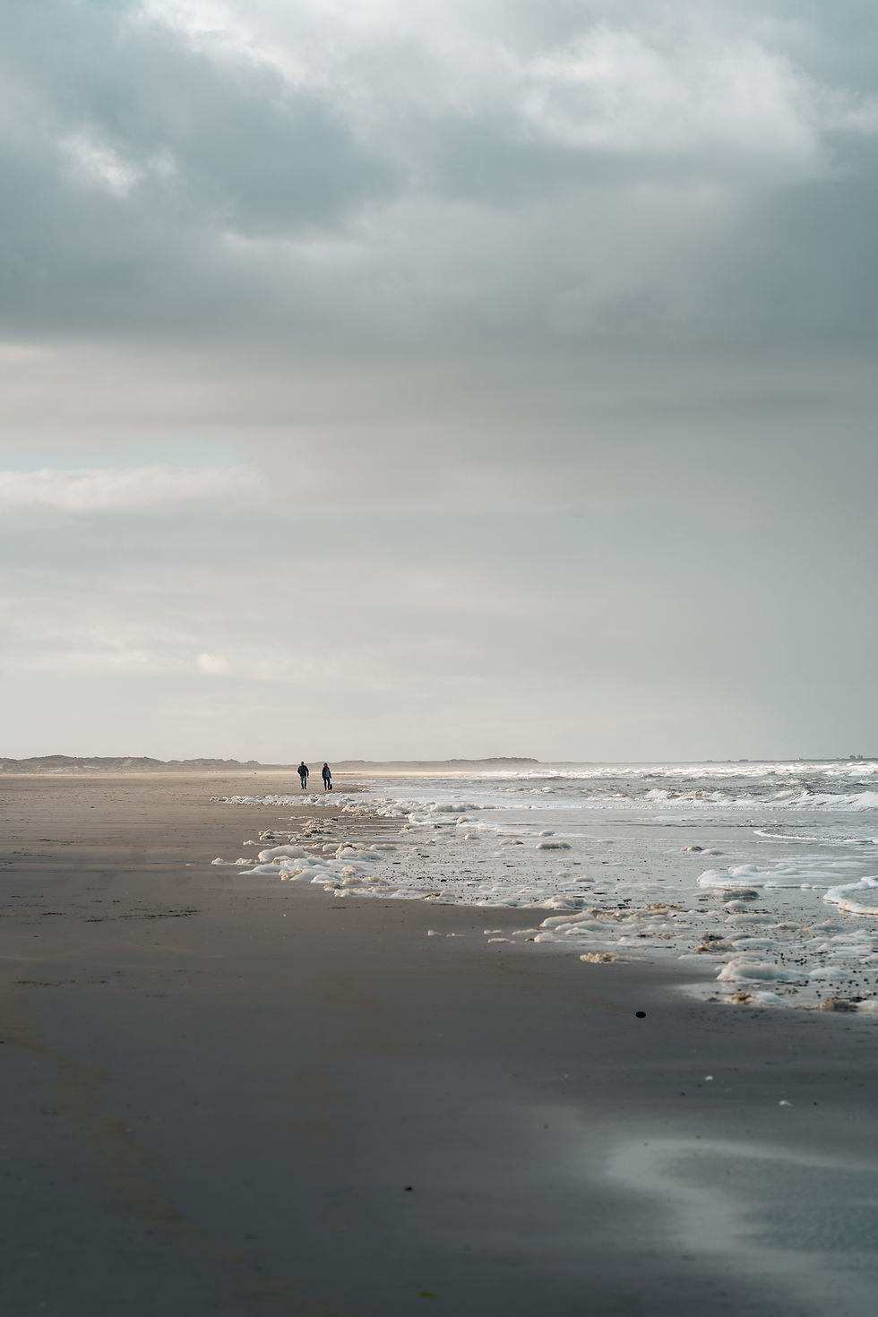 nordisches Wetter mit Regen und Spaziergängern am Strand von Dänemark