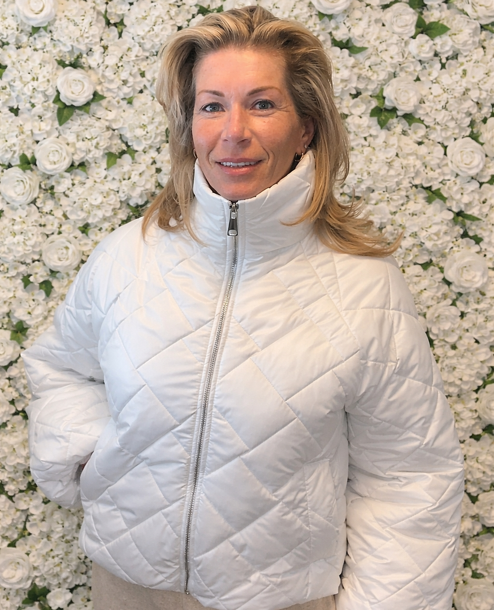 Vrouw in trendy witte gewatteerde jas.
