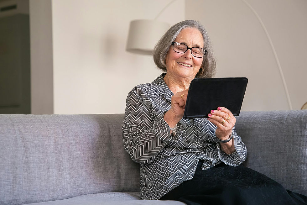 Eine glückliche Seniorin hantiert mit ihrem Tablet