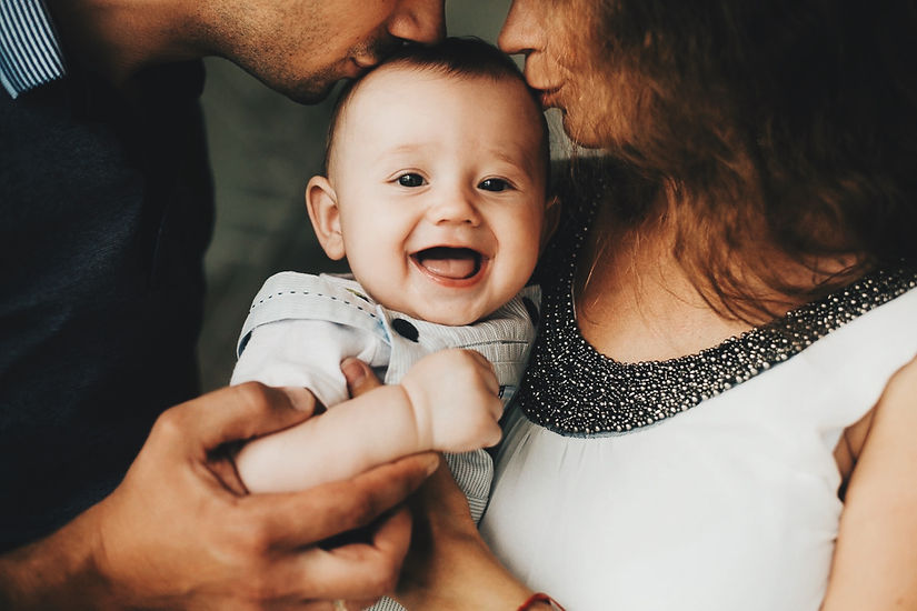 smiling-baby-being-kissed-by-parents-at-home-2026-03-17-04-06-50-utc.jpg