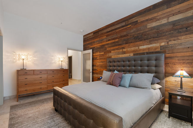 primary master bedroom with walk-in closet and wood accents