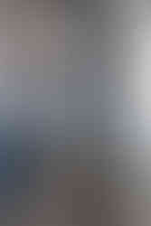 Bureau bleu avec des étagères murales, des livres et des cadres de photos. Une chaise en bois clair de style scandinave.