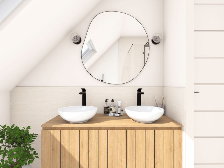 Décoratrice d'intérieur Nantes Vannes. Salle de bain lumineuse avec un meuble vasque en bois de chêne clair, deux vasques blanches, robinetterie métal noir, miroir de forme organique, faïence en travertin, murs blancs.