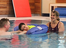 pupil enjoys hydrotherapy session, supported by physiotherapist and Learning, Care and Therapy Practitioner.