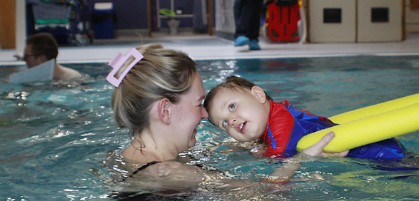 Happy mother and baby enjoy swimming lesson