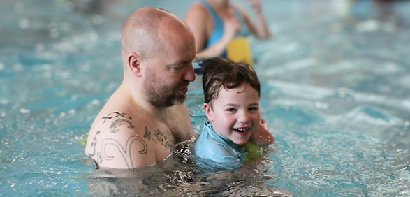 Happy father and son enjoying a swim lesson