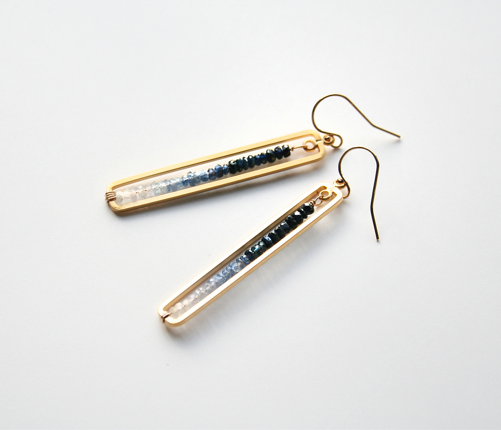 Gold rectangle frame with blue sapphire gemstones, ranging from dark blue to white.