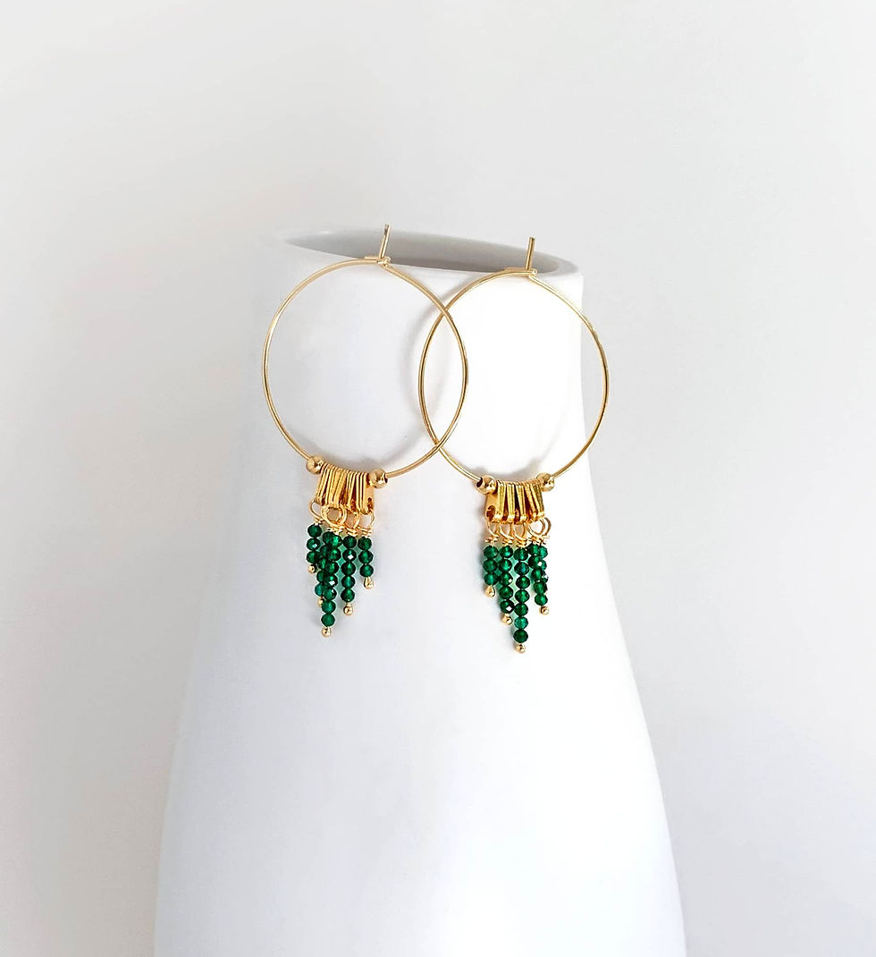 Thumbnail: Hoop earrings with small green gemstones dangling from them.
