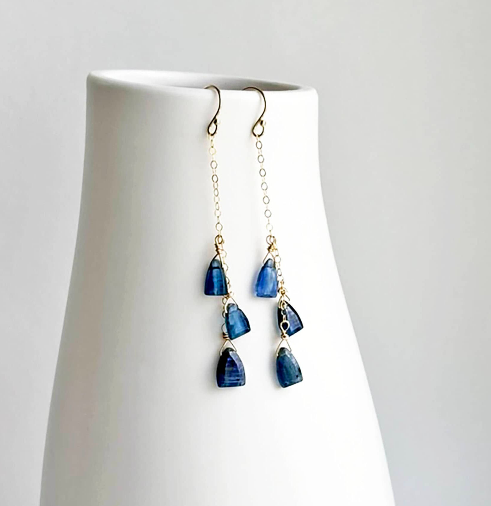 Drop chain earrings with three blue kyanite gemstones in the shape of a triangle hanging from the middle to bottom of chain.