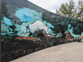 Abstract mural with blue, white, and dark tones on a curved wall