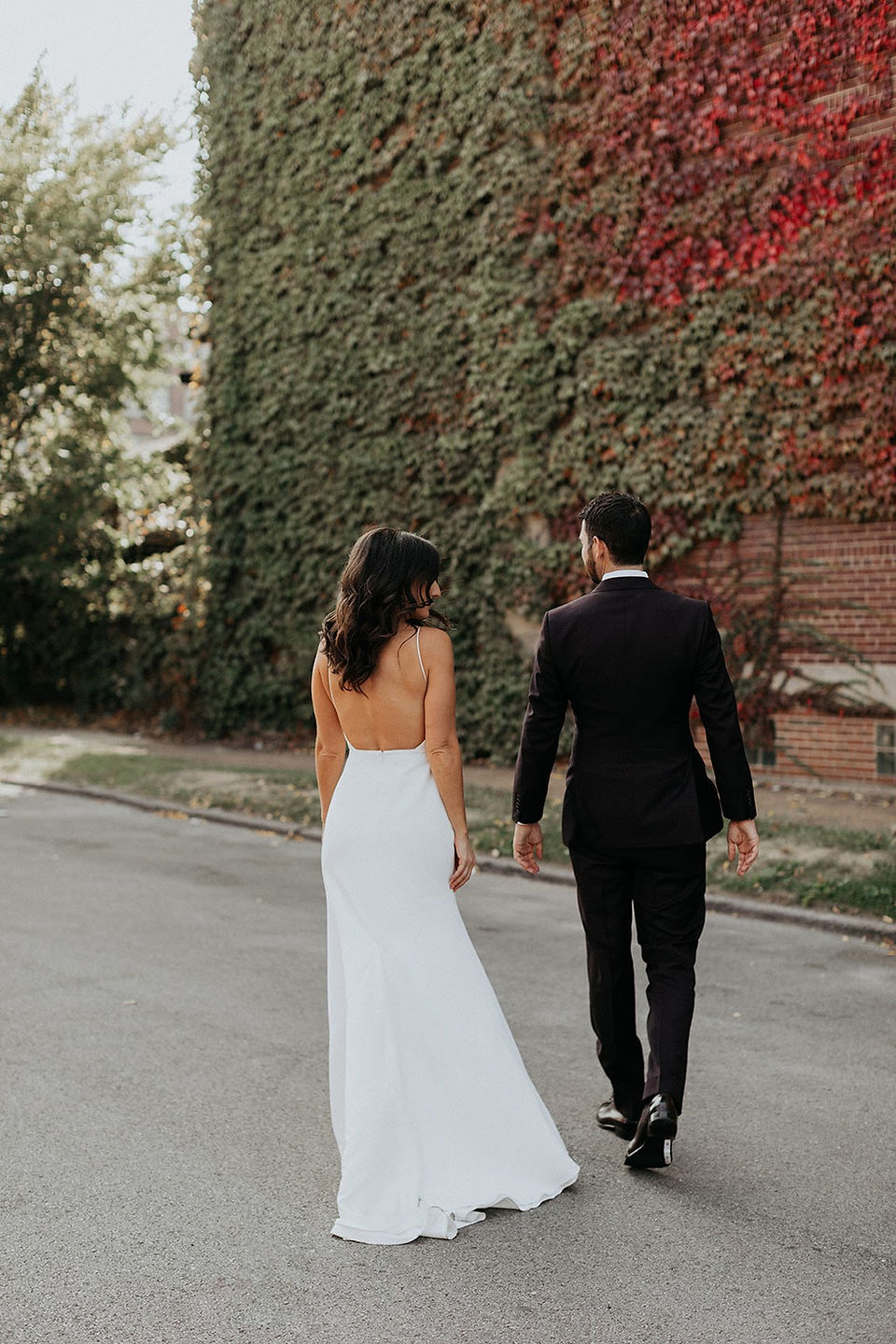 Couple in front of ivy wall on wedding day
