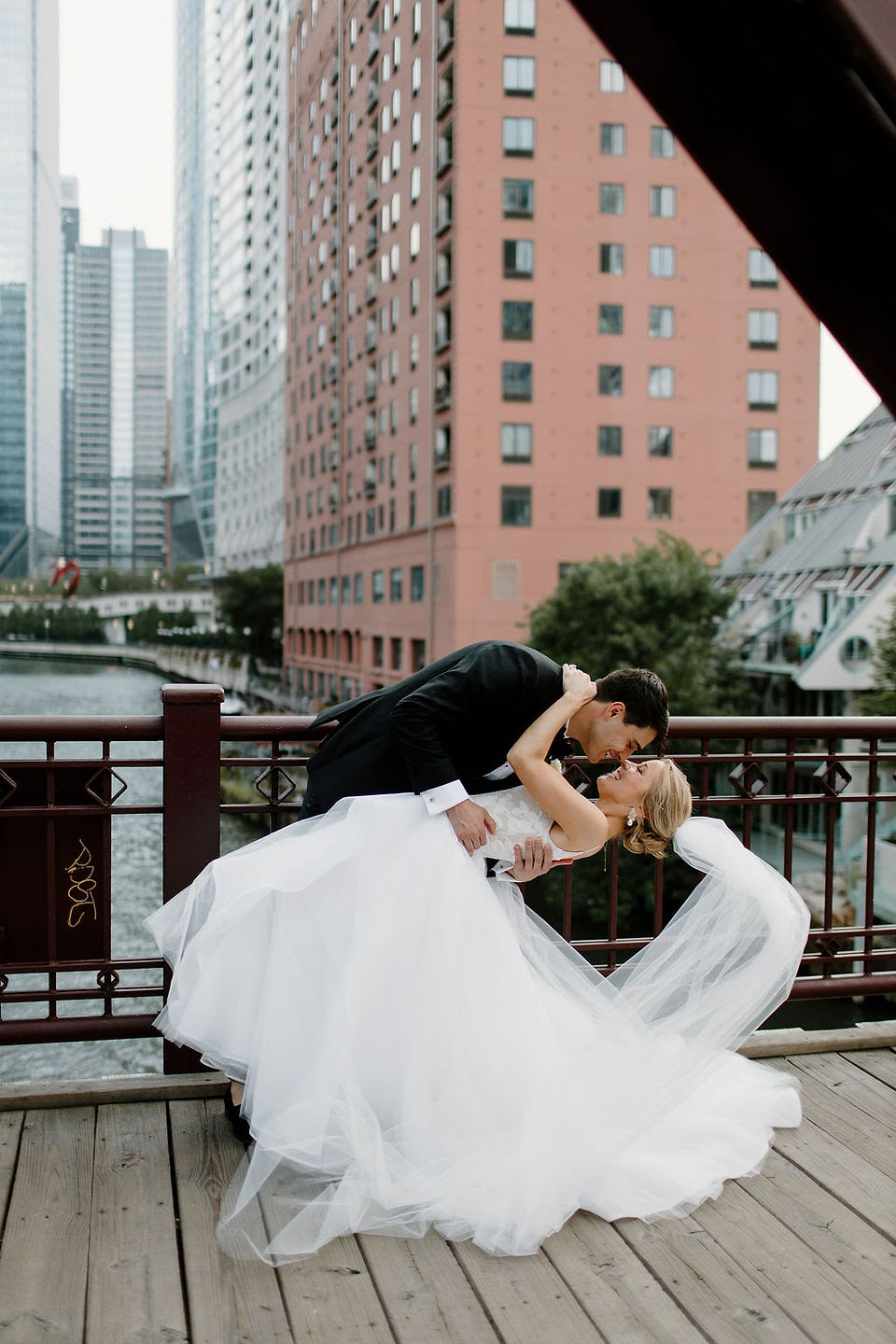 Bride and groom kissing on bridge