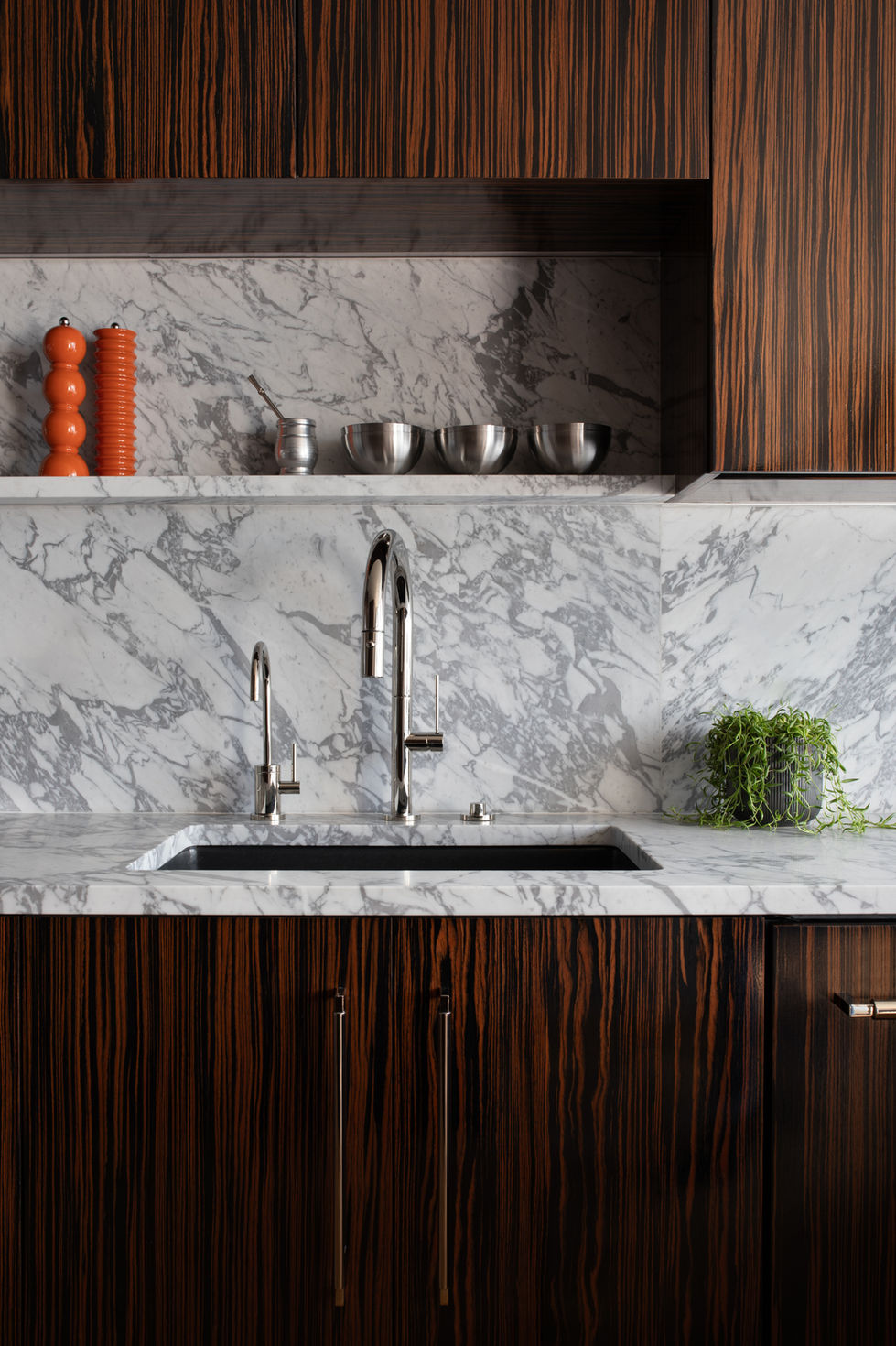 Our Mid-Century Project kitchen with macassar wood cabinets, California Faucets fixtures, and marble countertops and slab backsplash.