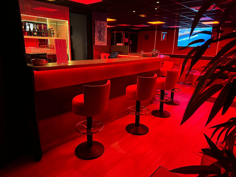 Bar élégant, éclairage rouge, ambiance intime