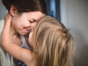 A mother hugging her daughter. 