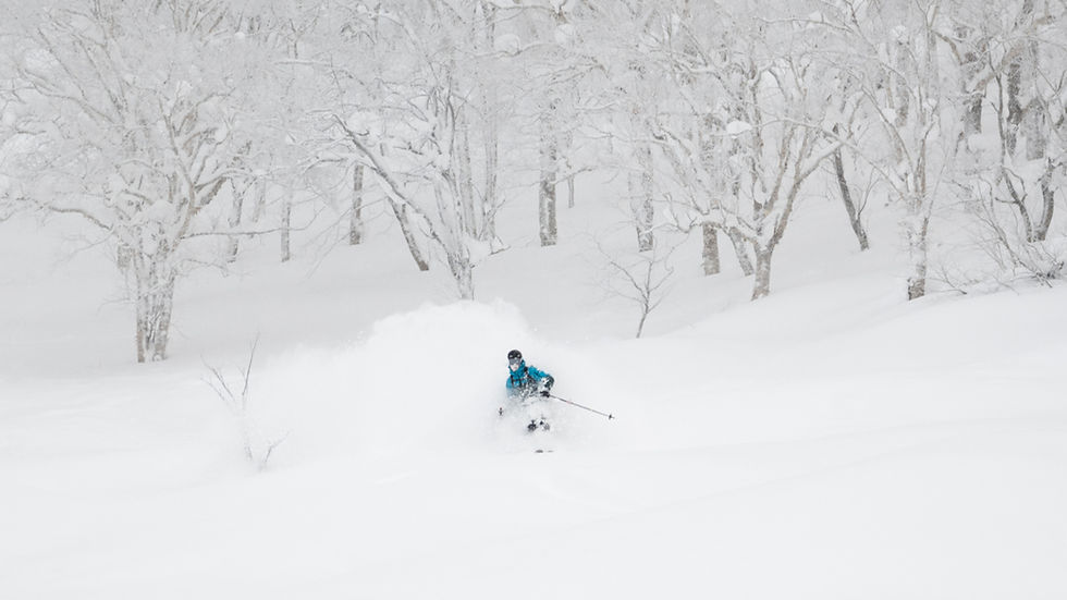 High angle view of snow-covered mountain scenery under a clear blue sky. Guided tour in Niseko
