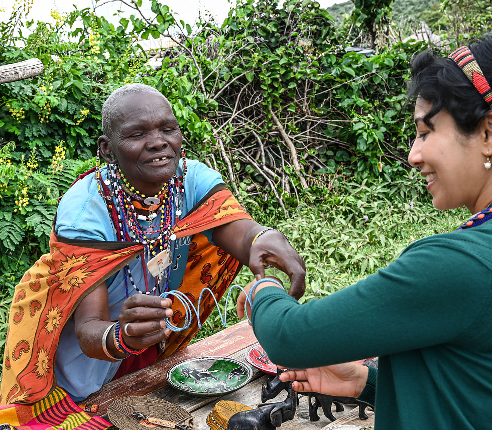 A warm exchange between Sarmin and a local artisan, sharing vibrant Maasai jewelry in a village in Masai Mara.