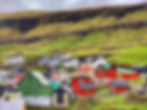 Nestled in the enchanting Faroe Islands, this vibrant town showcases colorful houses against a backdrop of lush, terraced hills, creating a charming, fairy tale atmosphere.