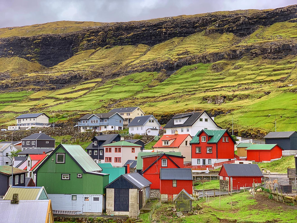 Nestled in the enchanting Faroe Islands, this vibrant town showcases colorful houses against a backdrop of lush, terraced hills, creating a charming, fairy tale atmosphere.
