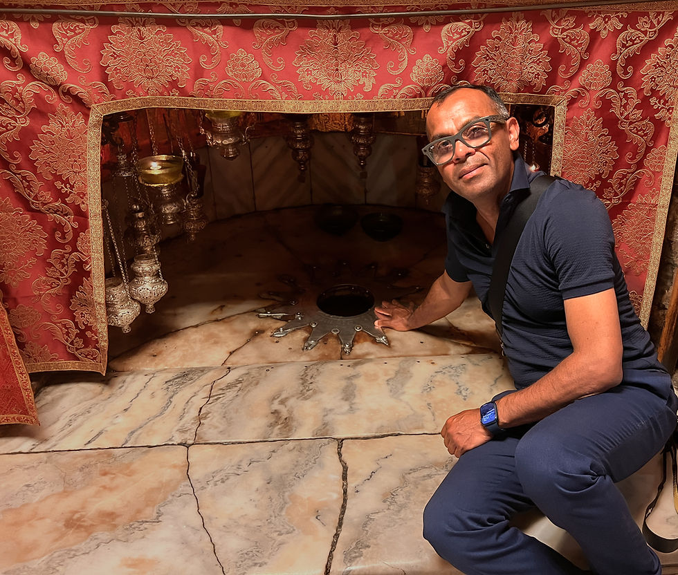 Bahar kneels beside the iconic silver star marking the traditional birthplace of Jesus Christ in Bethlehem.