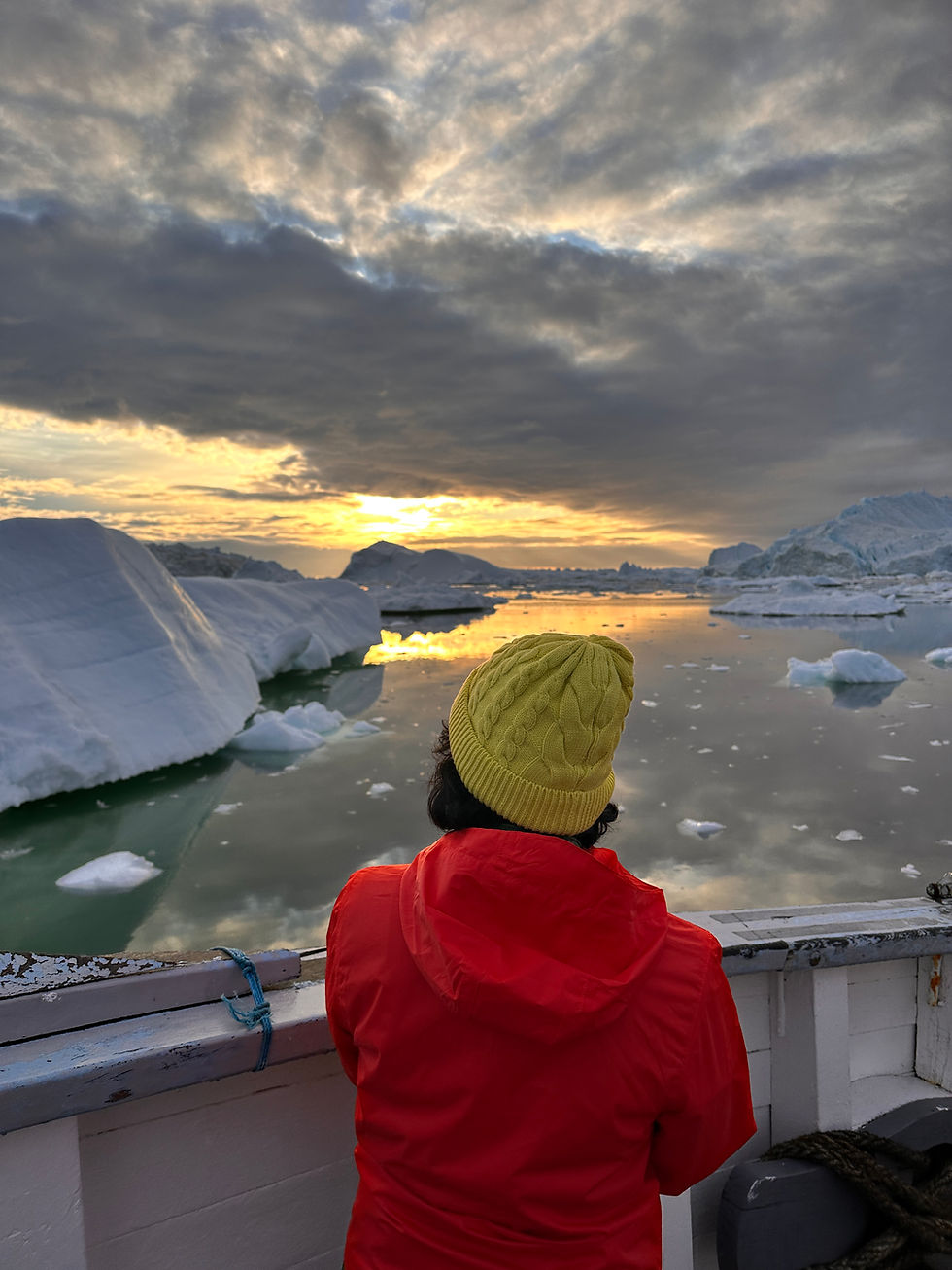 Sarmin enjoys the breathtaking sunset over Disko Bay, Ilulissat, surrounded by majestic icebergs.