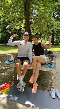 Personal Trainer Michael Christian Meyer mit einer Kundin auf einer Tischtennisplatte im Park in München während einer funktionellen Übungseinheit.