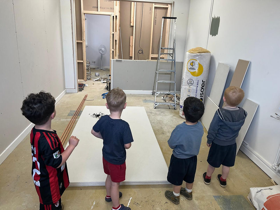The back of 4 children looking at a room in a state of redecoration