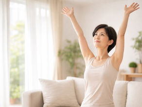 西宮の40代女性が朝のリビングで両腕を上げて気持ちよくストレッチしている様子