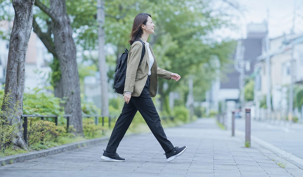通勤途中の歩道を歩いて運動量を増やしている30代の女性