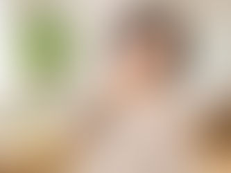 自宅のリビングで首の後ろに手を添え、軽く首をケアしている30代女性