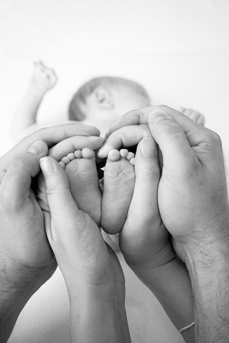 černobílá fotografie s detailem rukou muže a ženy a dětských nožiček