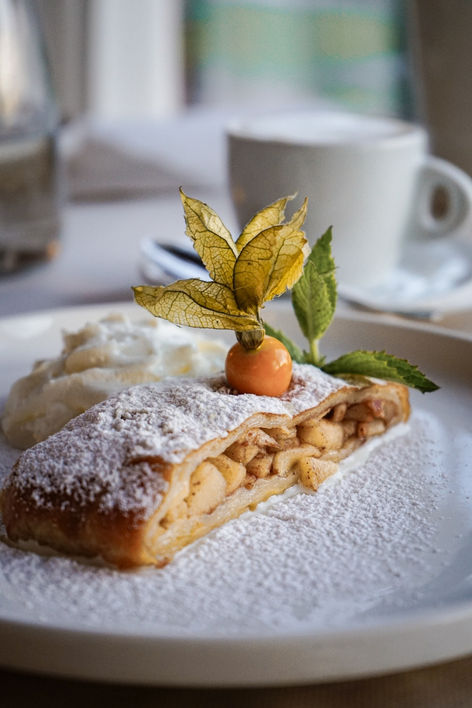 jablečný štrůdl posypaný cukrem s hrnkem kávy