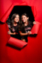 Smiling female athletes in jerseys, torn red background