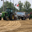 Green tractors pull weighted sled in tractor pull competition. Medina County Fair.
