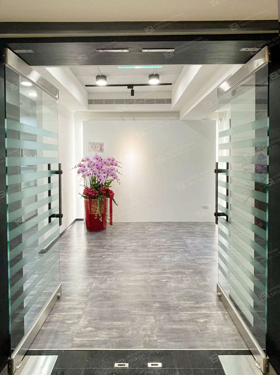 辦公室入口設計，大理石地坪搭配石紋牆面與間接照明，營造專業且穩重的迎賓動線