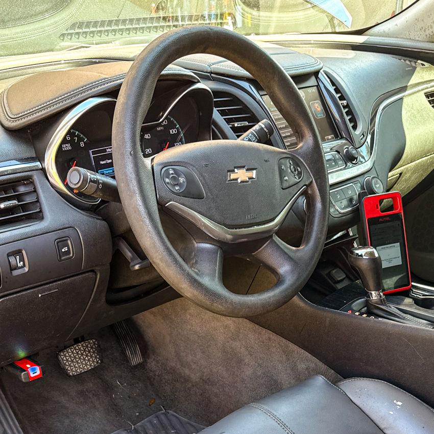 Locksmith programming a Chevrolet car key with a diagnostic tool.