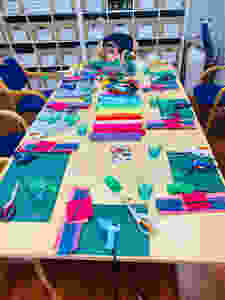 A table laid with felt and tools to make felt flowers