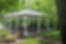 White gazebo with chairs in a garden