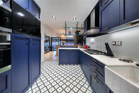 Modern blue parallel kitchen with patterned floor tiles and sleek cabinets.