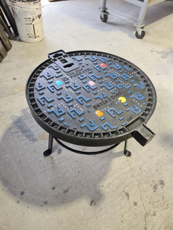 table basse en mode Pac-Man réalisée avec un regard de voirie sur un support métallique