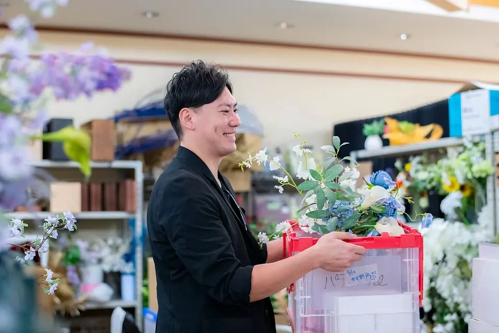 花材の倉庫で、造花や葉を運ぶ。