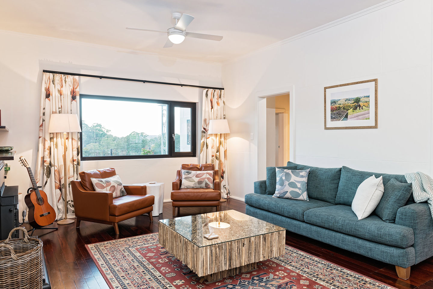 A lounge room with a rug, sofa and chairs