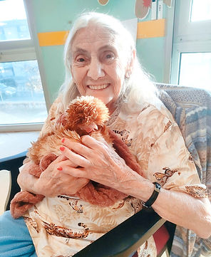 Une résidente fait un câlin à la poule Pomponnette.