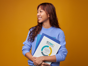 Smiling woman with a copy of the ID360 Leadership Report